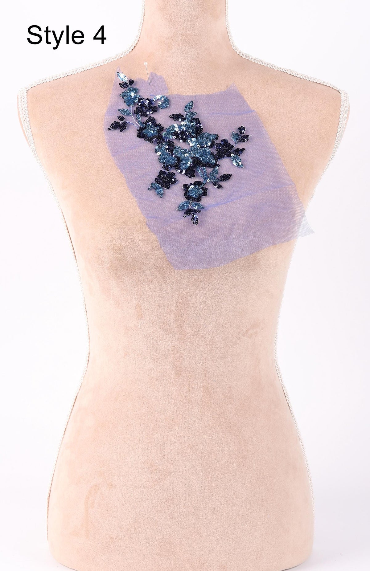 a mannequin with a decorative piece of fabric on its back, which appears to be a floral design.