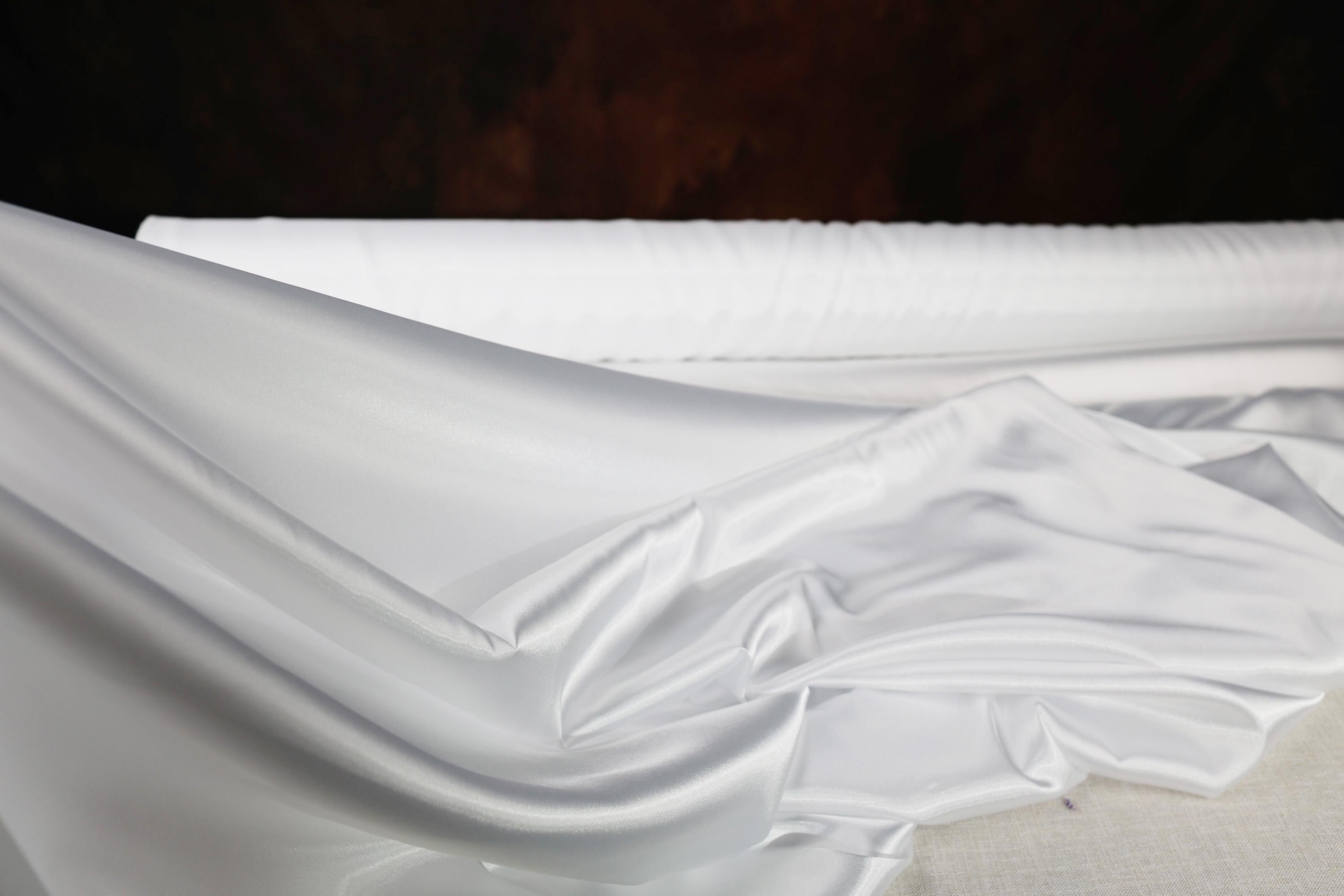 a close up of a bed with white sheets