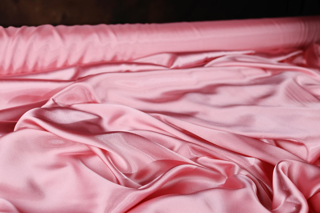 a pink sheet is laying on a bed