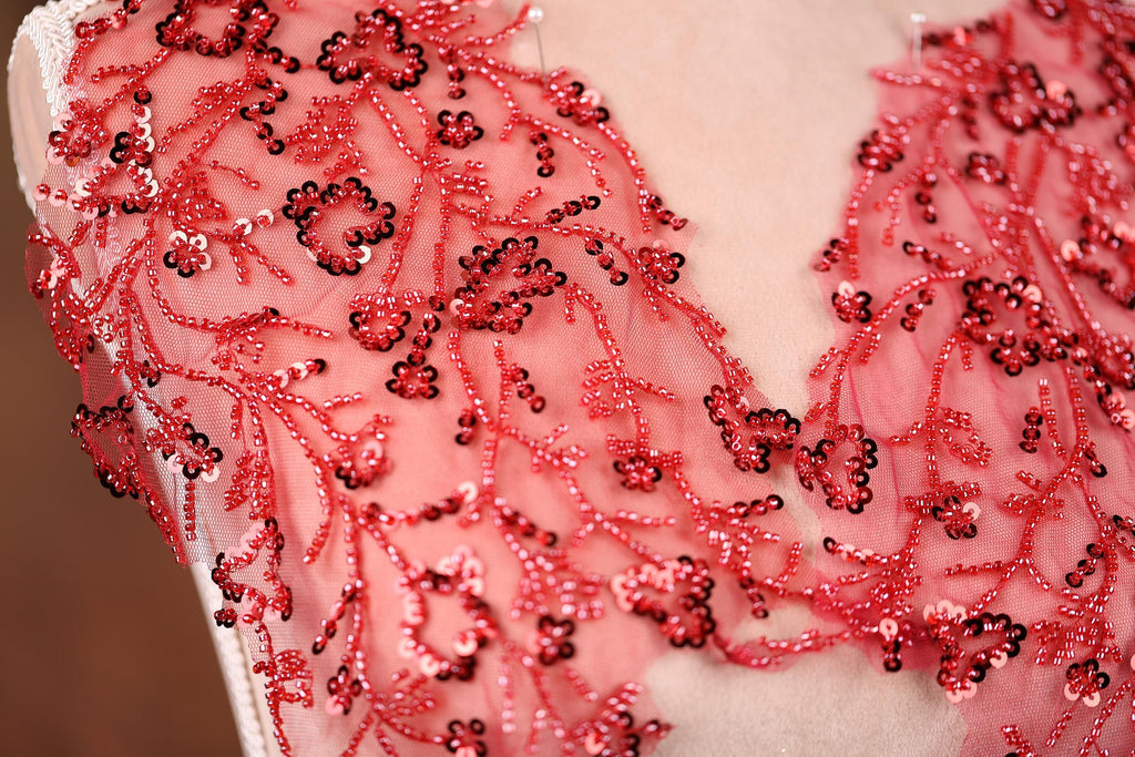 a close-up view of a red and black sequined dress, with the intricate details of the design visible.