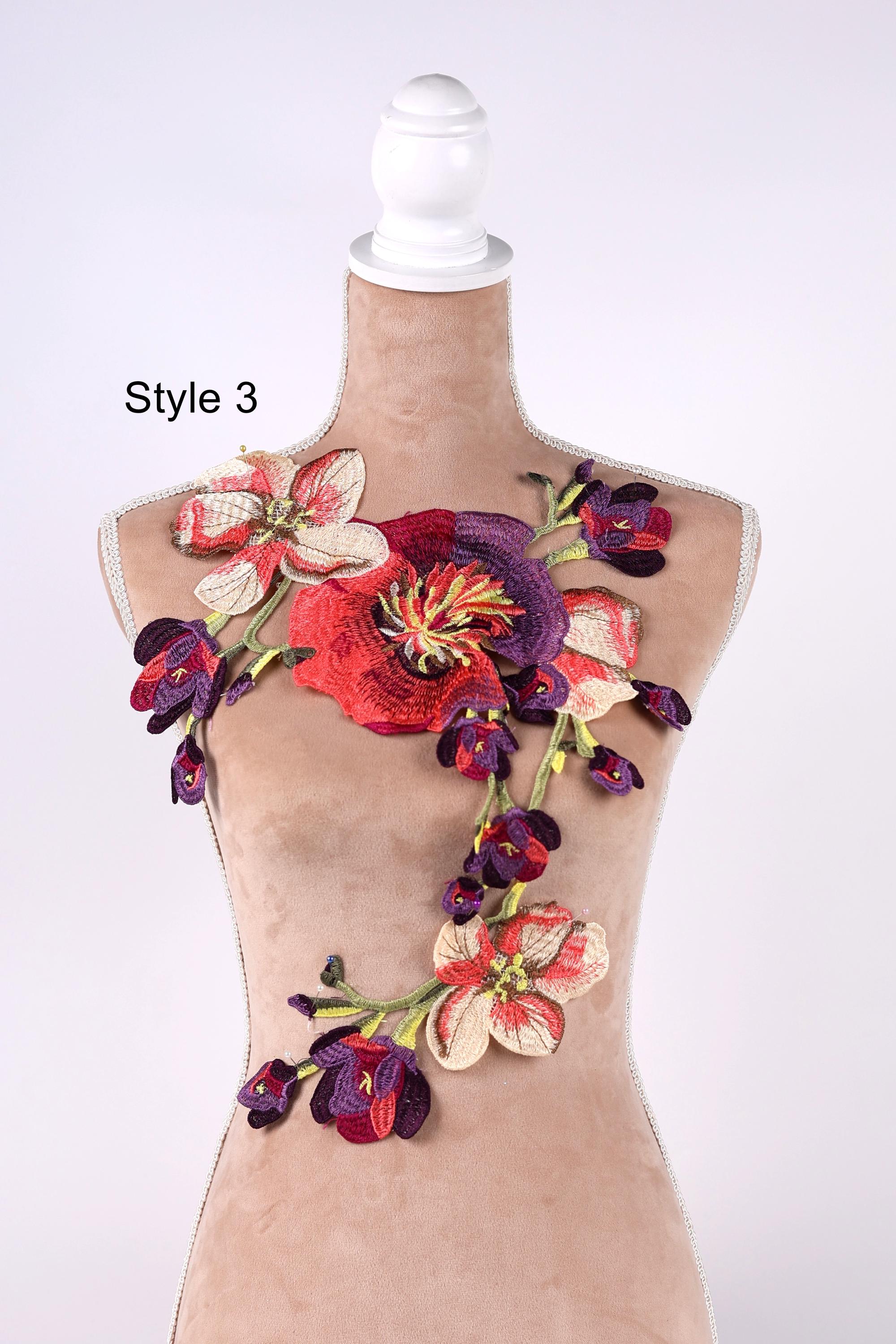 A mannequin with a floral embroidered design on its bust, featuring a variety of colorful flowers and leaves.