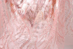 The image is a close-up of a fabric with a pink and silver pattern, featuring a delicate and intricate design.