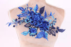 A mannequin torso with a decorative blue floral embroidery on it.