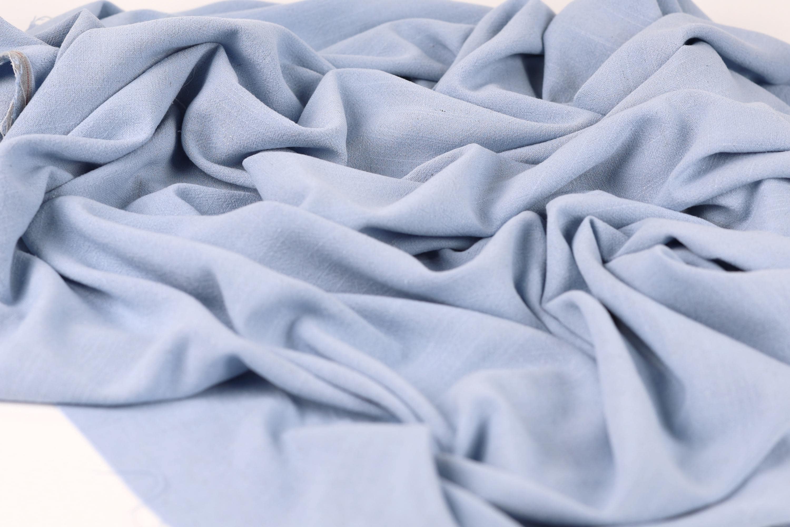 a close-up view of a crumpled, light blue fabric, possibly a piece of clothing or textile.