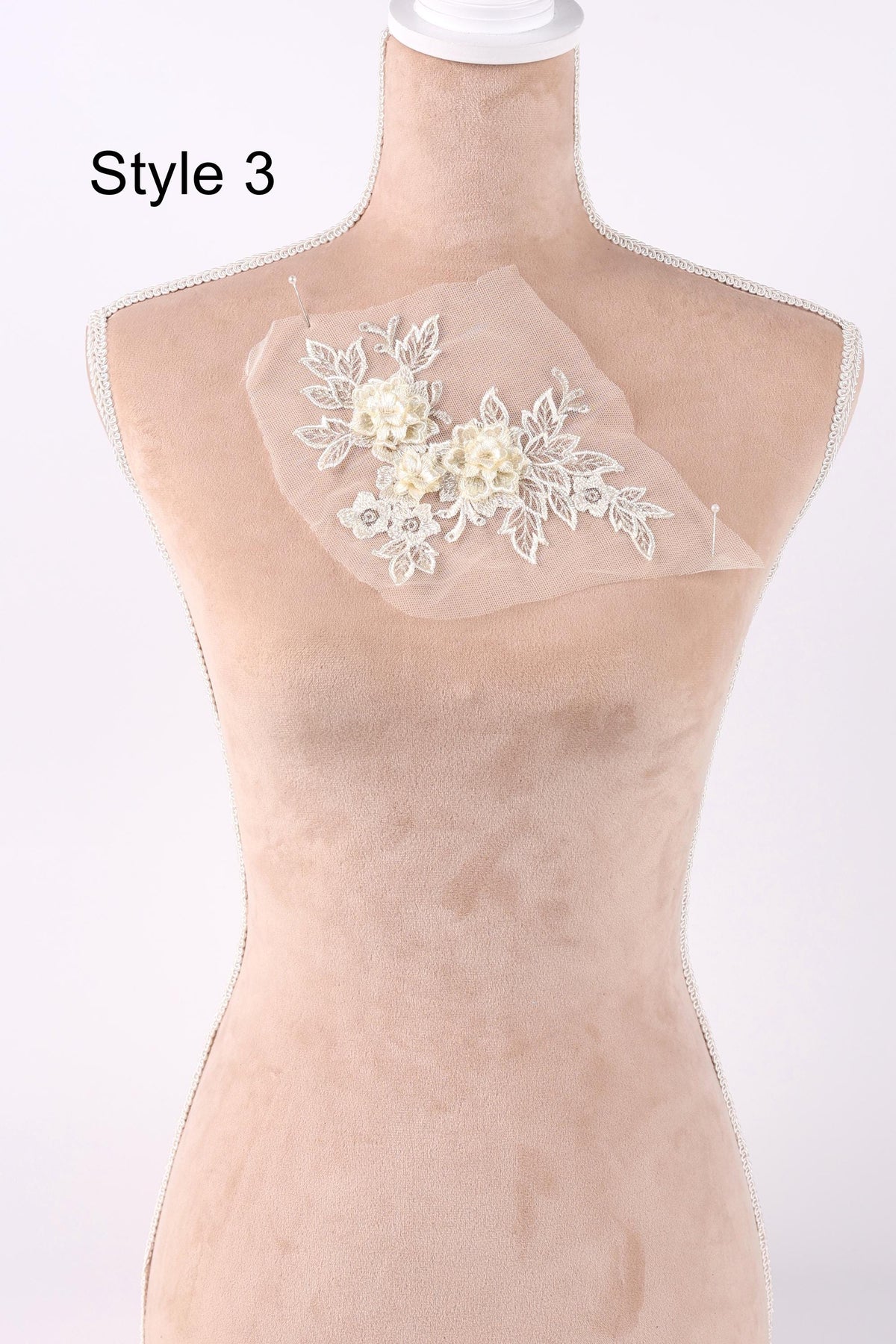 A mannequin with a white lace flower design on its bust.