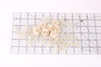 a delicate arrangement of white roses and lace on a transparent ruler.