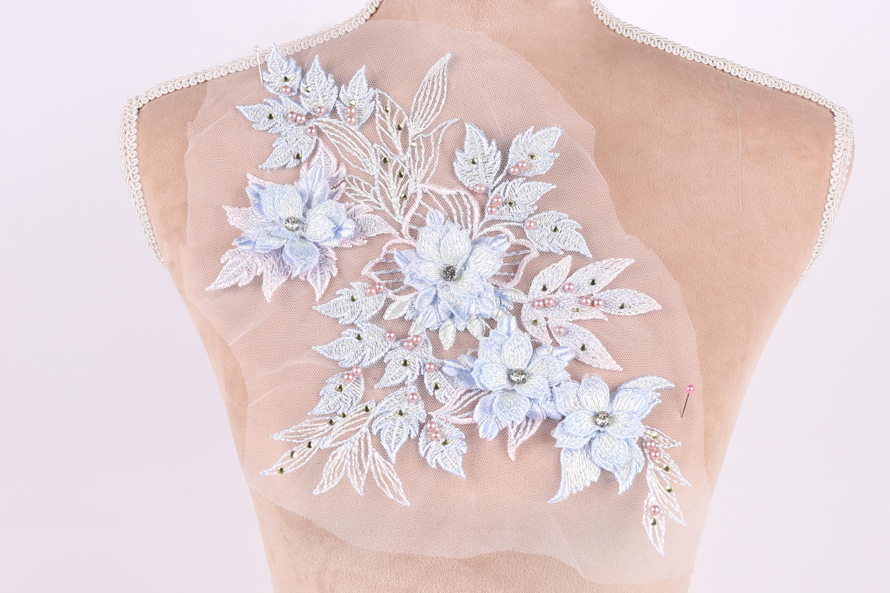 A mannequin torso with a delicate floral embroidered patch on the back.