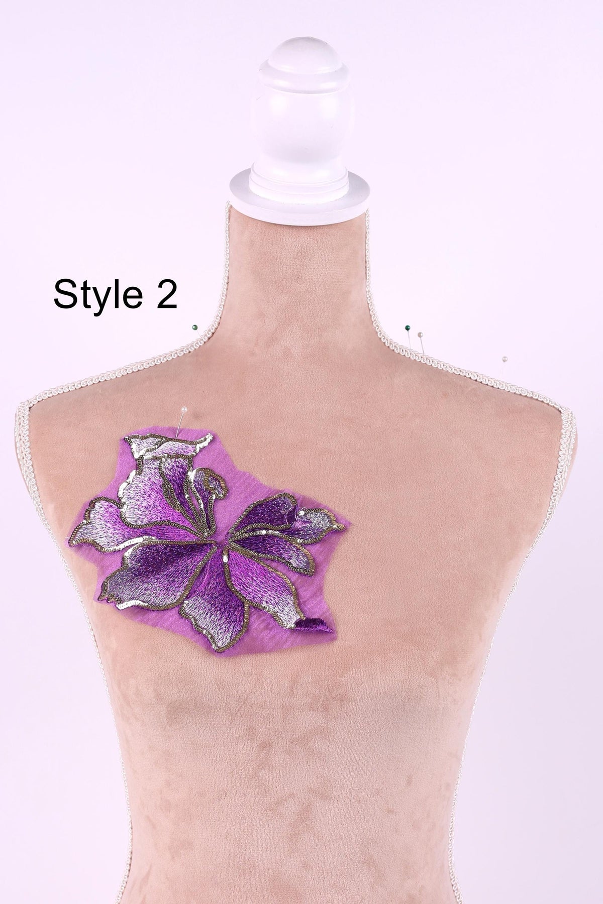 A mannequin with a purple flower embroidered on its chest.
