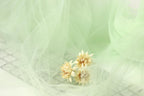 delicate white flowers resting on a light green fabric, creating a serene and peaceful scene.