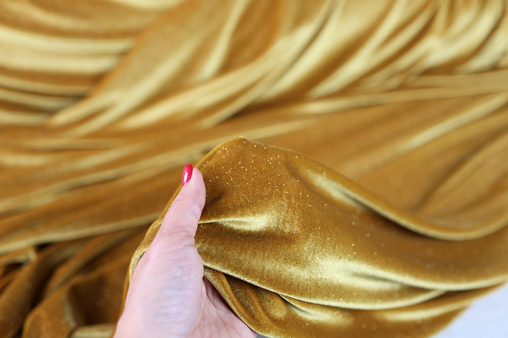 a woman's hand holding onto a gold cloth