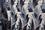 a close-up view of a fabric with a repeating pattern of blue and white leaves and flowers, adorned with gold sequins.