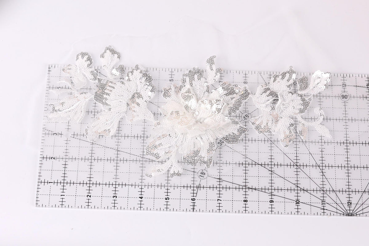 a close-up view of a transparent ruler with a floral pattern on it, placed on a white surface.