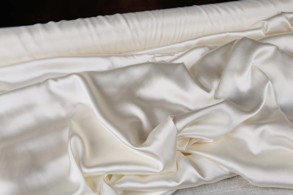 a close up of a bed with white sheets