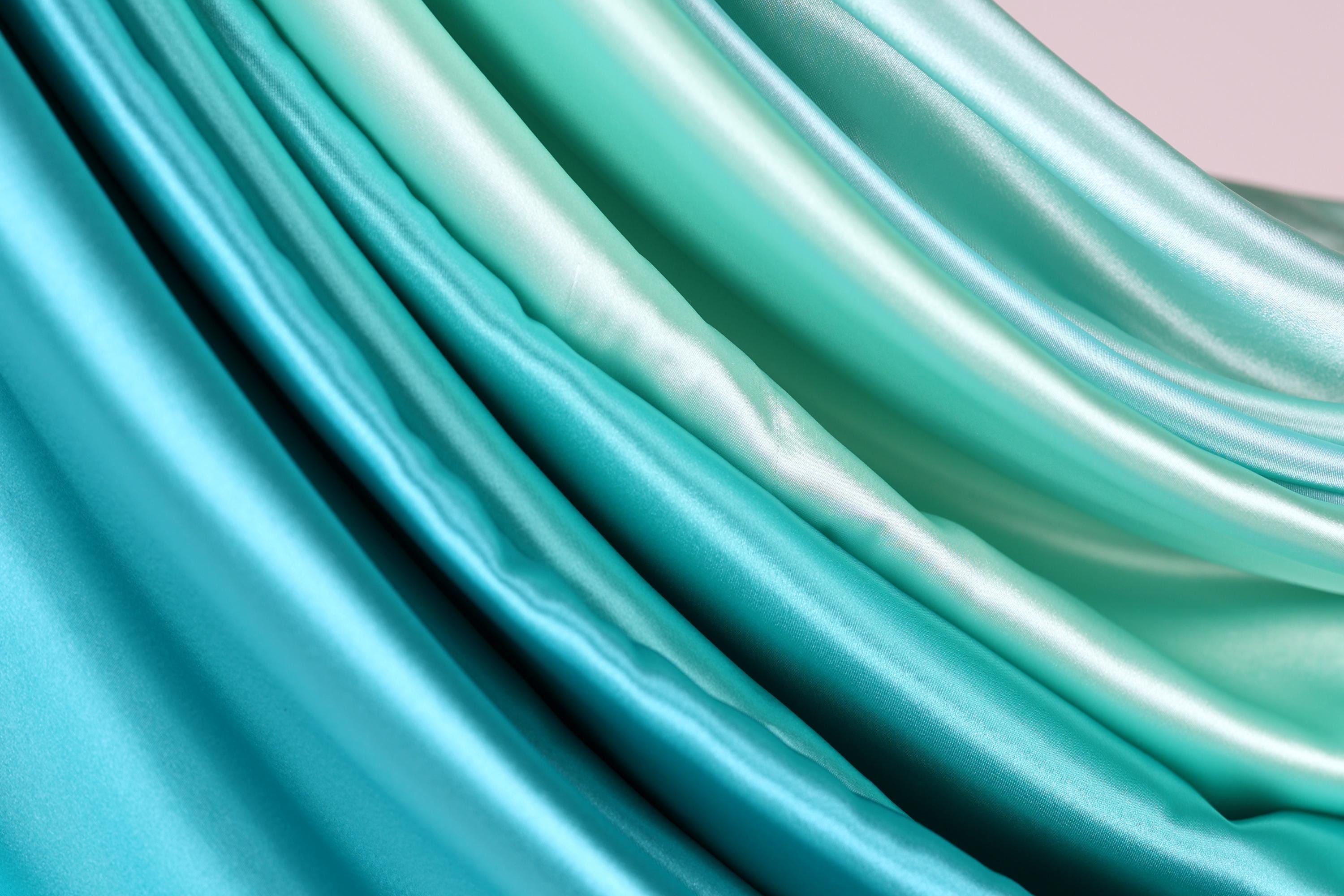 a close-up view of a fabric with a gradient of blue and green colors, creating a visually appealing and textured appearance.