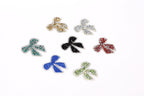 seven small, colorful, glittery bows arranged in a circular pattern on a white background.