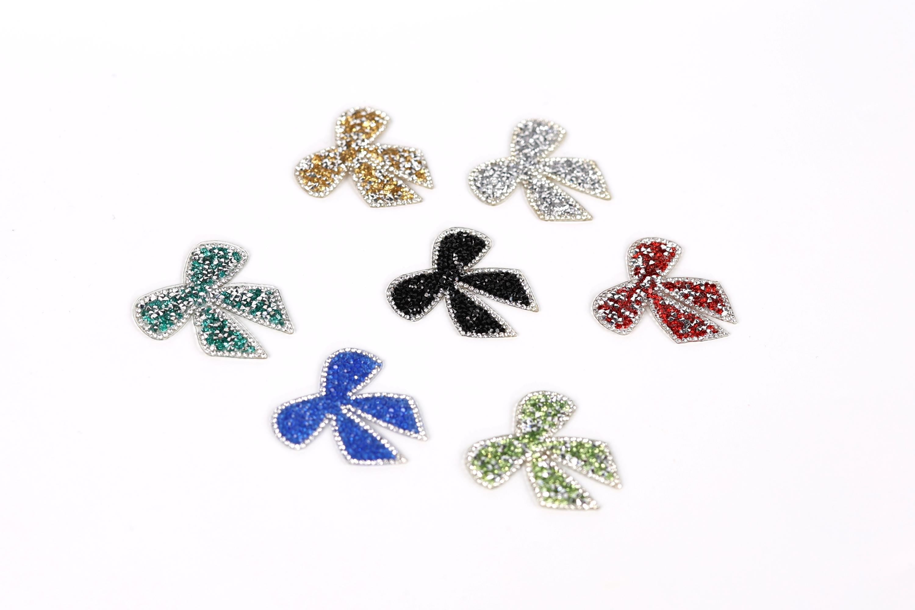 seven small, colorful, glittery bows arranged in a circular pattern on a white background.