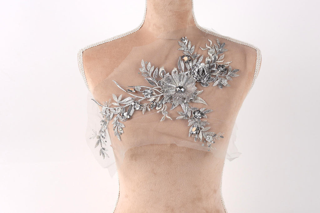 A mannequin with a decorative silver floral embellishment on its bust.