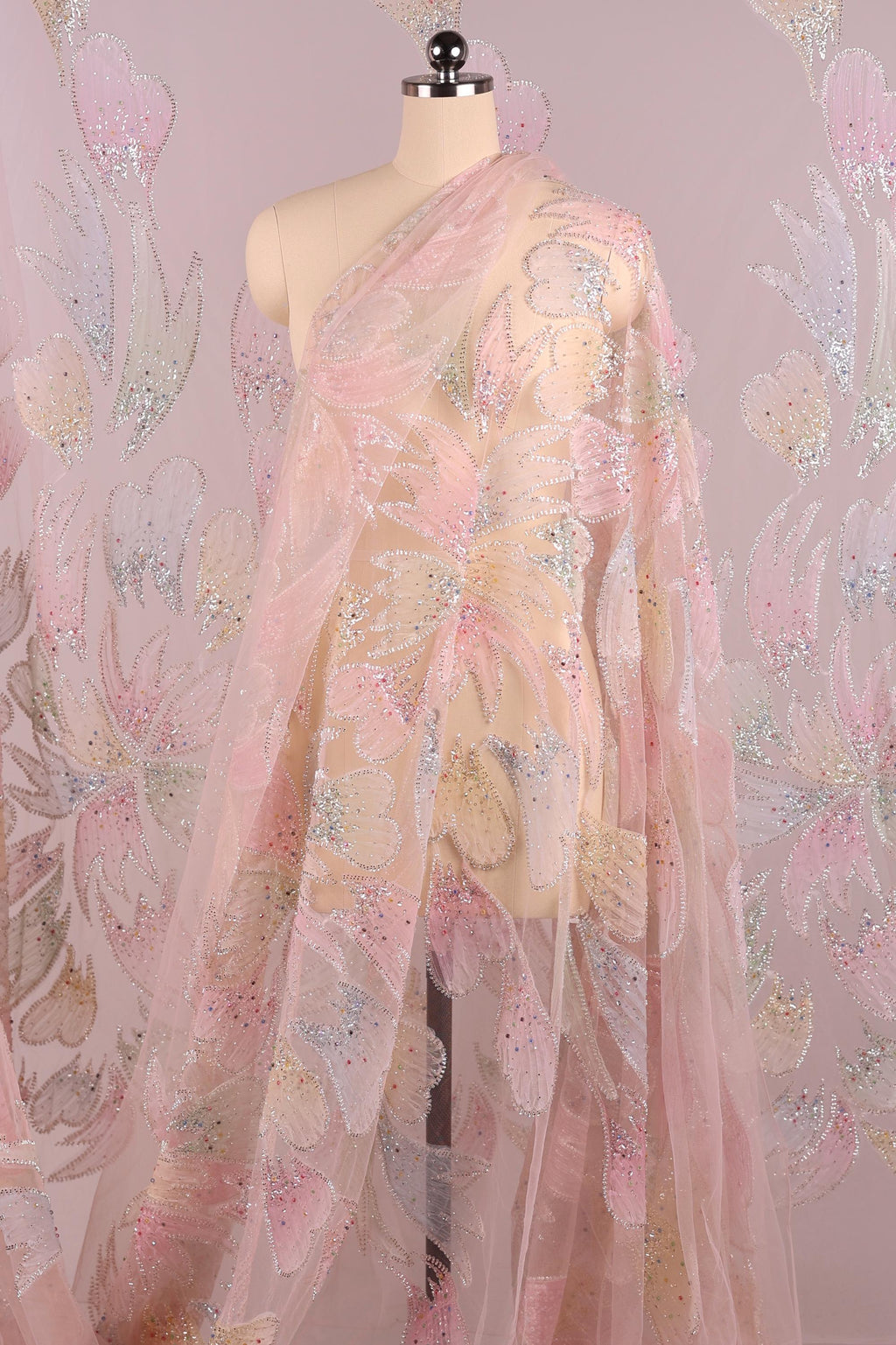 A mannequin wearing a pink and white floral print dress with a sheer, flowing skirt.