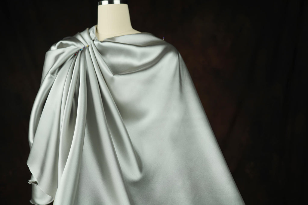 a dress on a mannequin with a cape on top of it