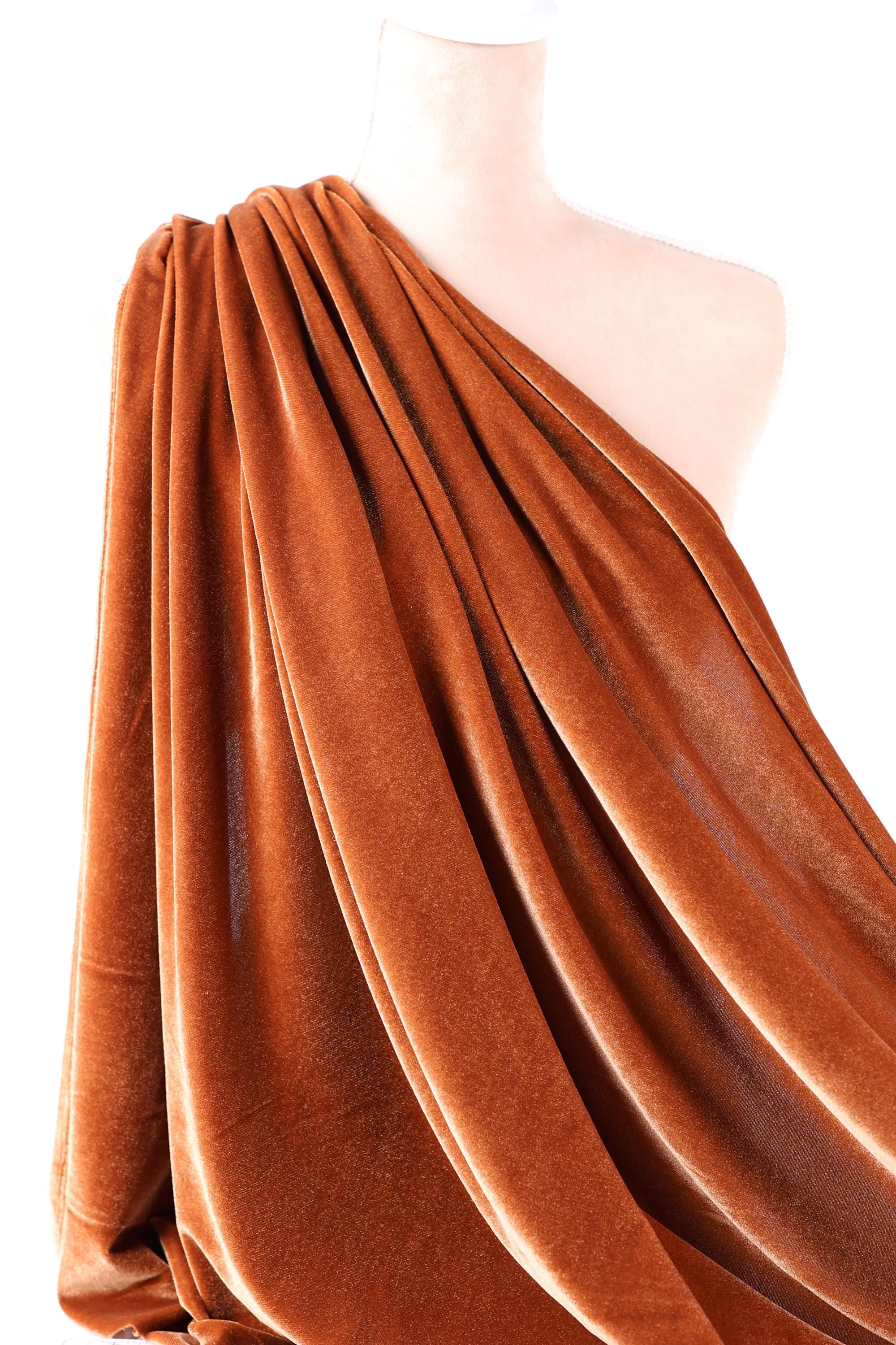 a close-up view of a piece of orange velvet fabric, with its folds and creases visible.