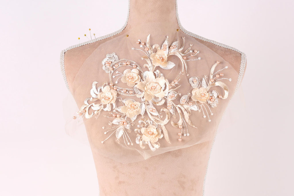 A mannequin with a delicate, floral-designed fabric covering its neck.