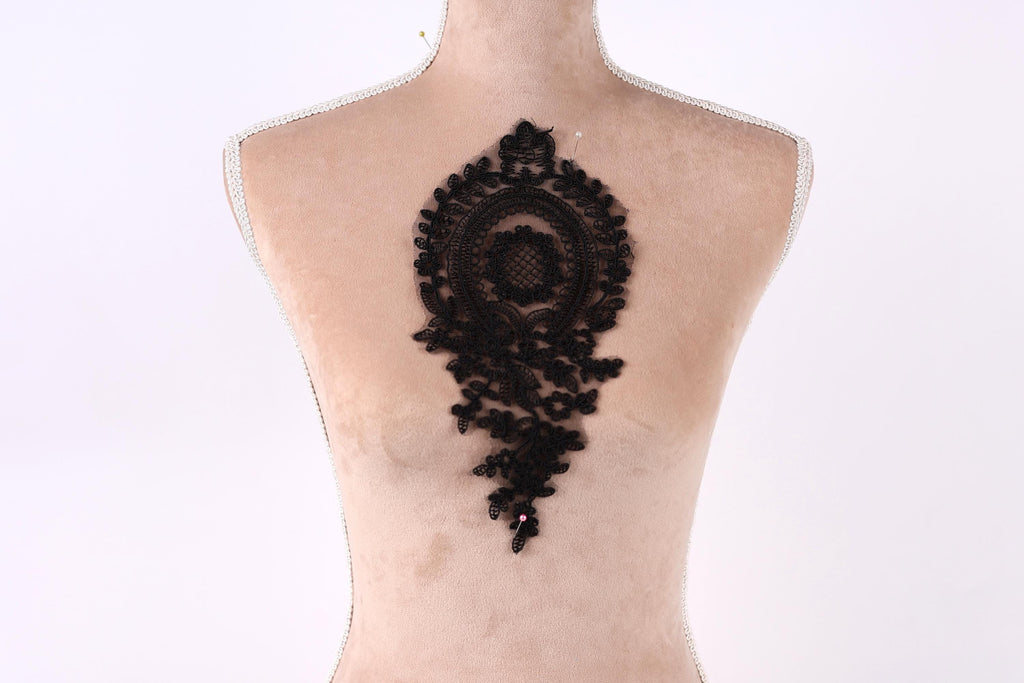 a mannequin with a black lace design on its back.