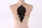 a mannequin with a black lace design on its back.