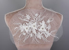 a bridal dress with flowers on the back of it
