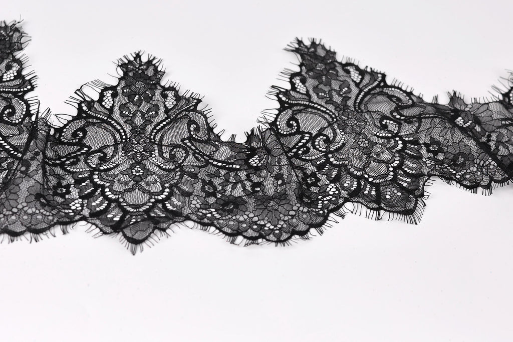 a close-up view of a black lace fabric with intricate, decorative patterns.