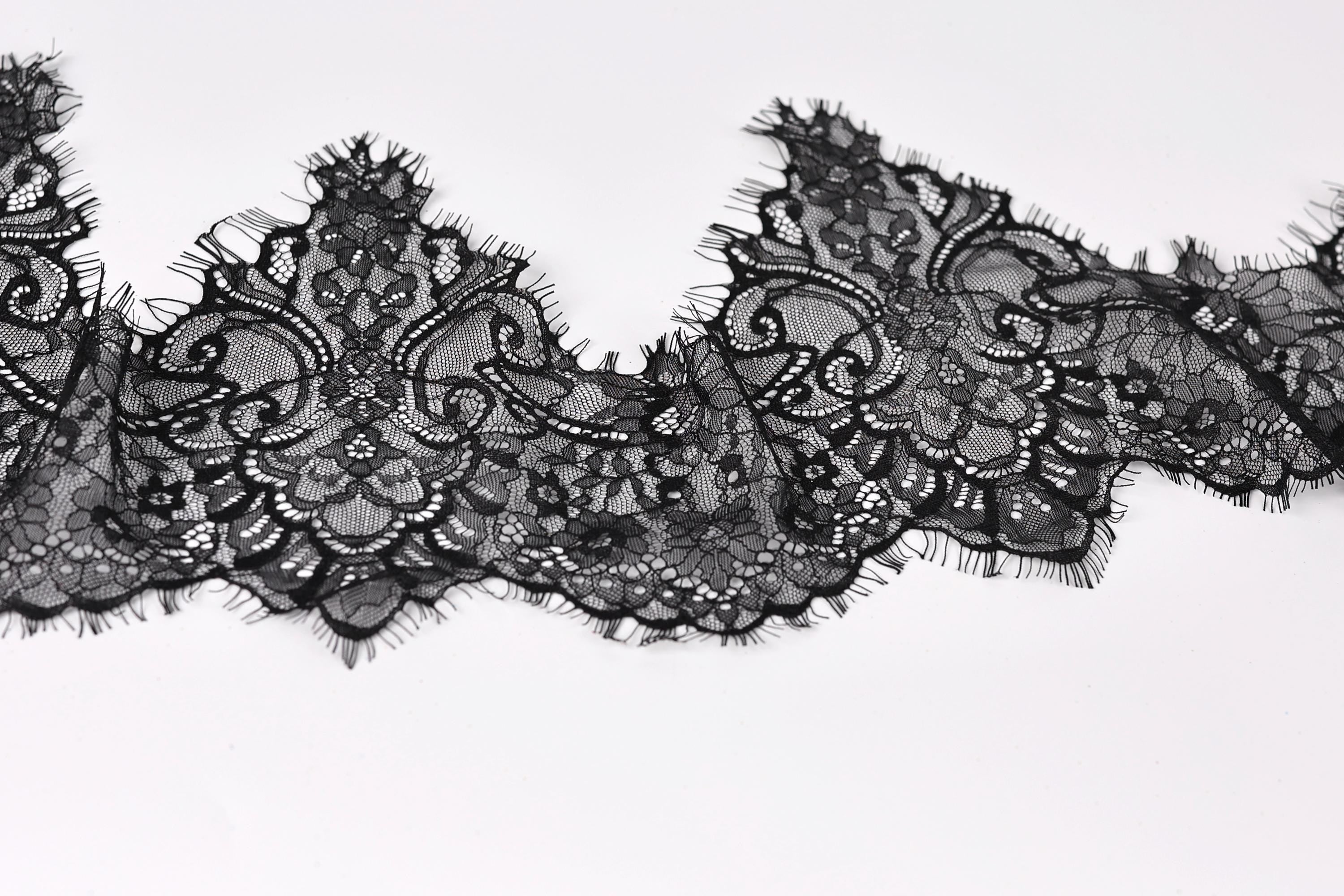 a close-up view of a black lace fabric with intricate, decorative patterns.