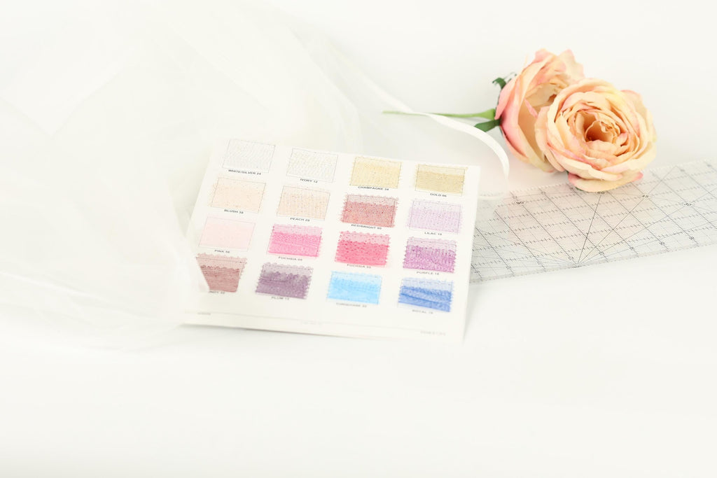 a color swatch with various shades of pink, along with a single pink rose and a piece of fabric or material with a grid pattern.
