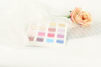 a color swatch with various shades of pink, along with a single pink rose and a piece of fabric or material with a grid pattern.