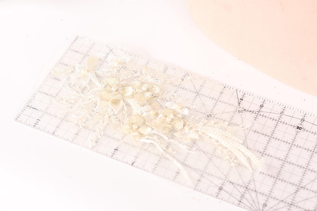 a clear ruler with a delicate floral design on it, placed on a white surface.