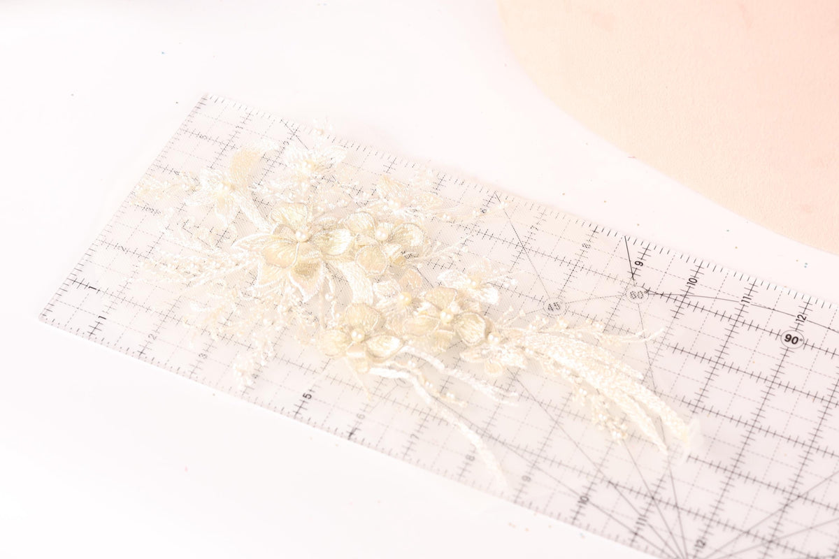 a clear ruler with a delicate floral design on it, placed on a white surface.