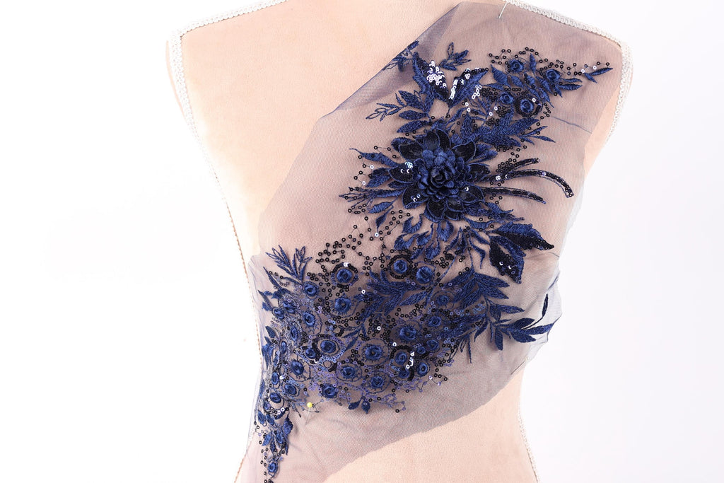 a mannequin with a sheer fabric back that has a floral design in blue and black.