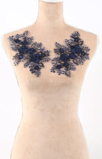 A mannequin wearing a beige dress with blue floral embroidery on the shoulders.