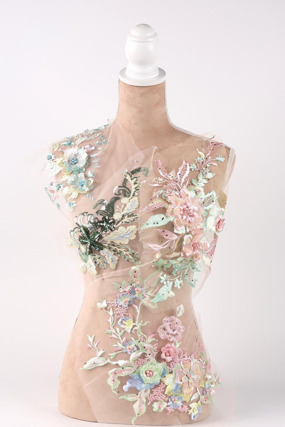 A mannequin wearing a dress with a floral pattern on the bodice and sleeves.
