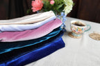 a stack of folded towels next to a cup of coffee
