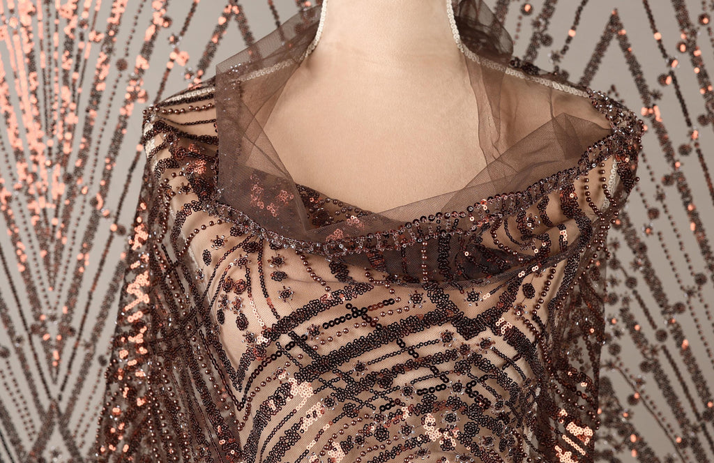 A mannequin wearing a brown sequin shawl with a sheer overlay.