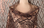 A mannequin wearing a brown sequin shawl with a sheer overlay.