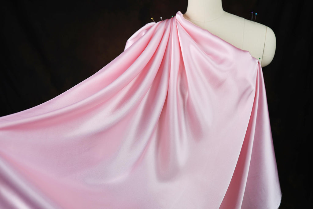 a mannequin wearing a pink draped dress