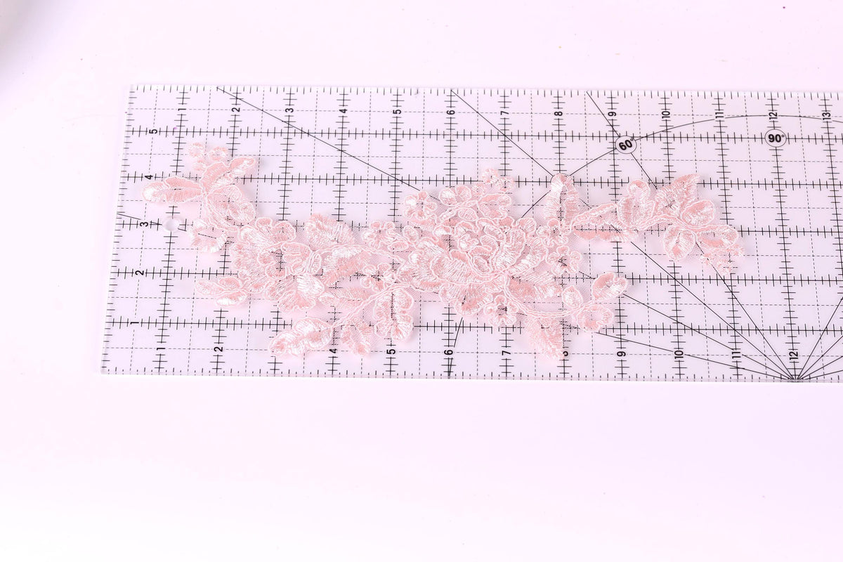 a clear ruler with a pink lace flower pattern placed on it.