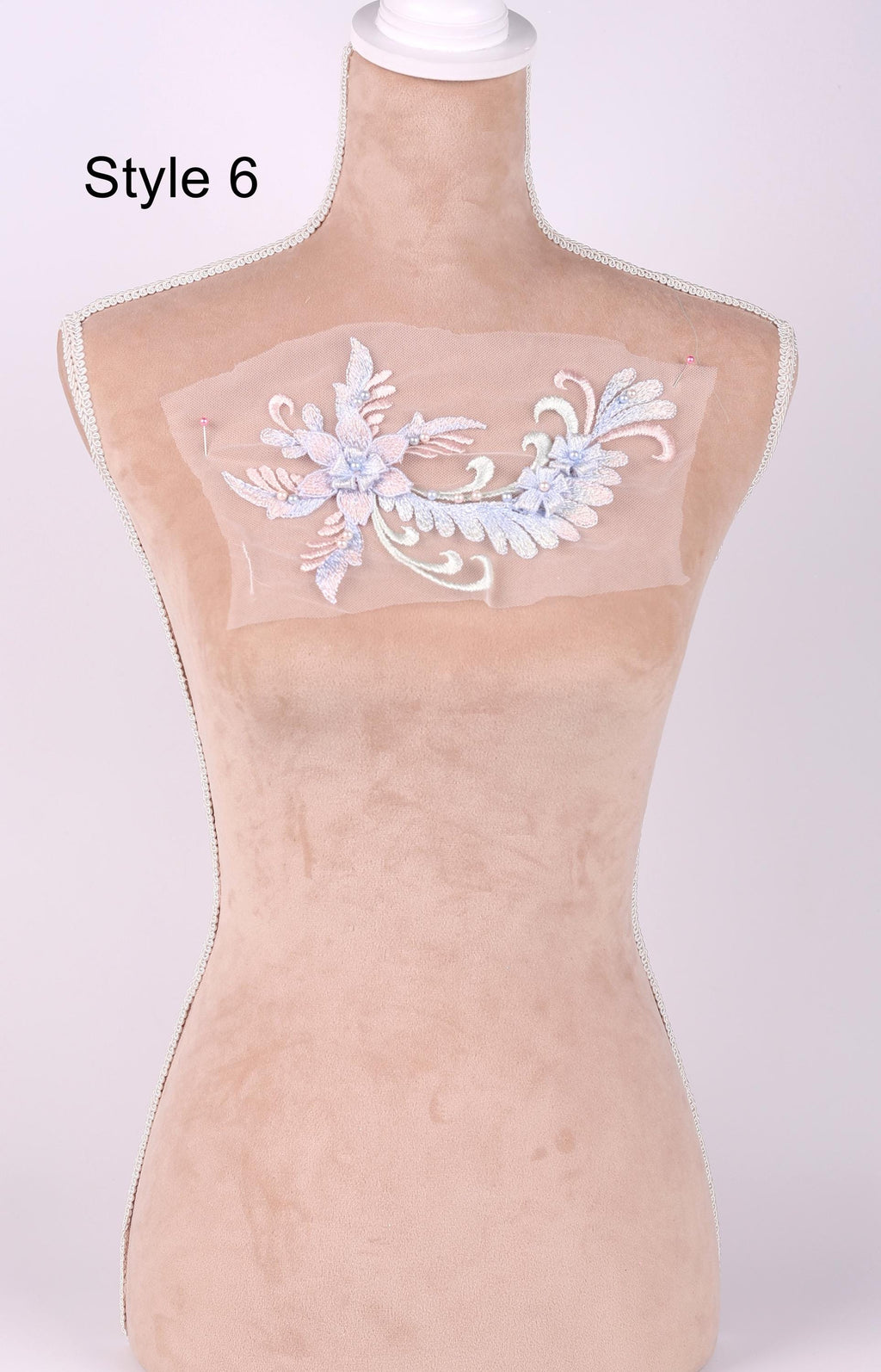 A mannequin with a decorative floral embroidered on its bust.