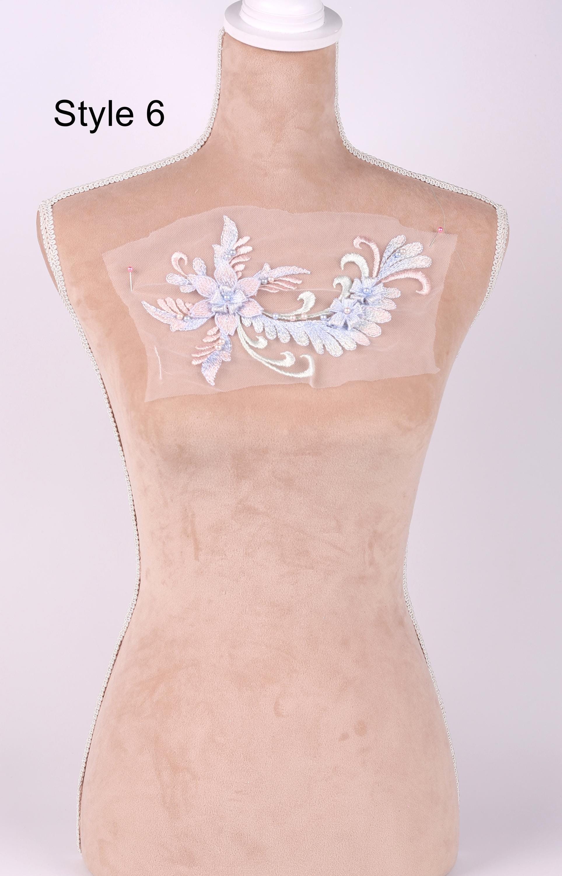 A mannequin with a decorative floral embroidered on its bust.