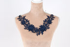 A mannequin wearing a necklace with a blue floral design.