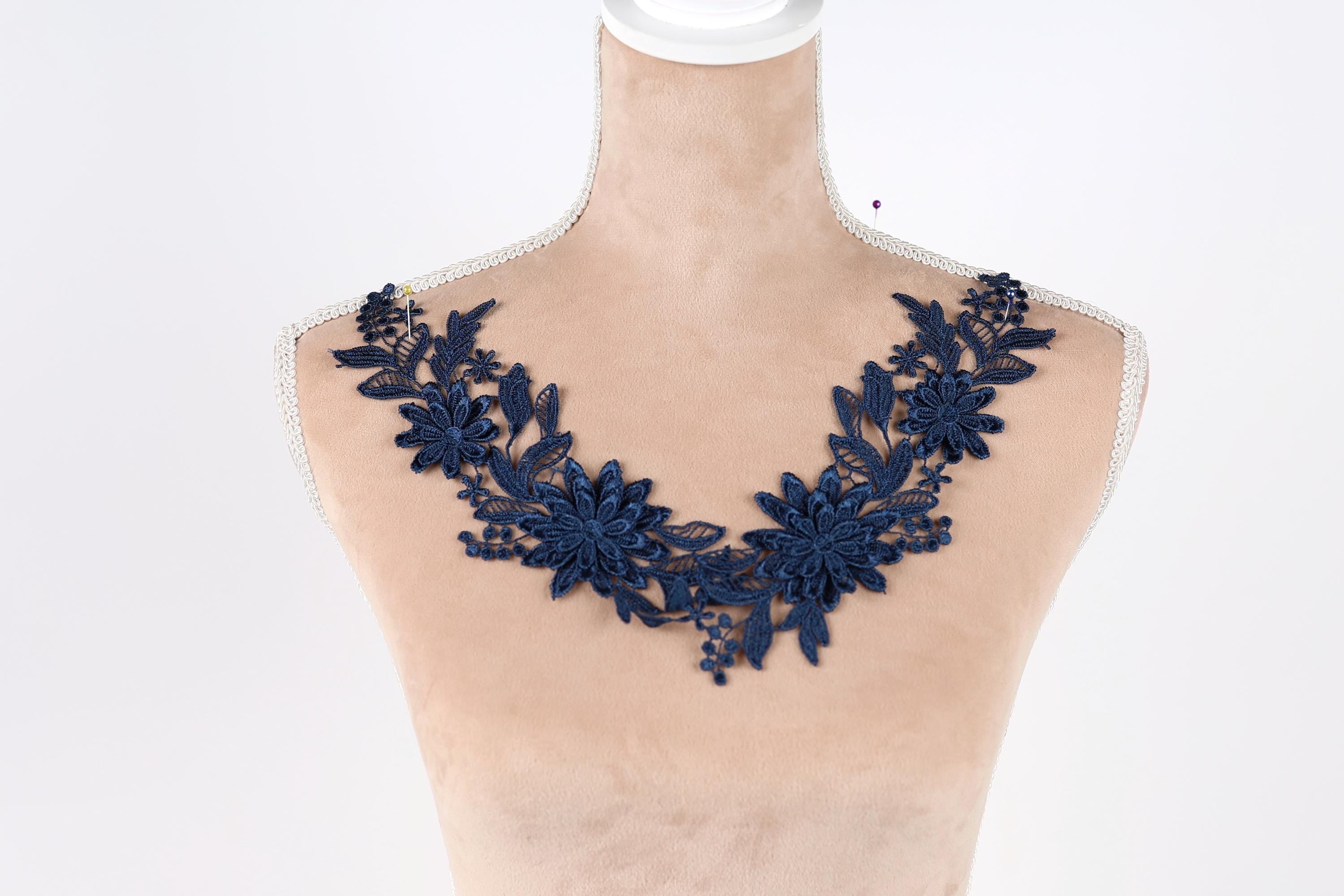 A mannequin wearing a necklace with a blue floral design.