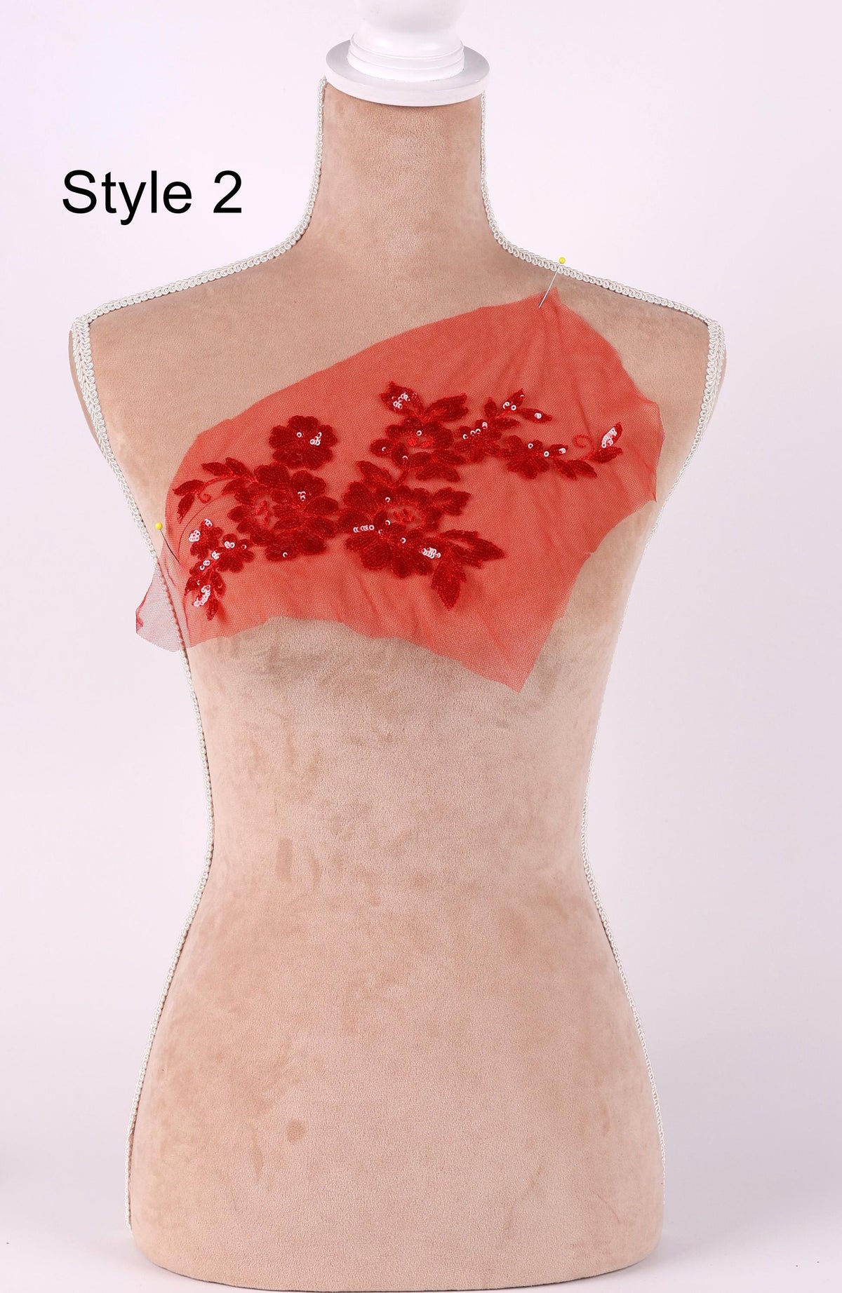 A mannequin with a red floral design on its chest, displayed against a white background.
