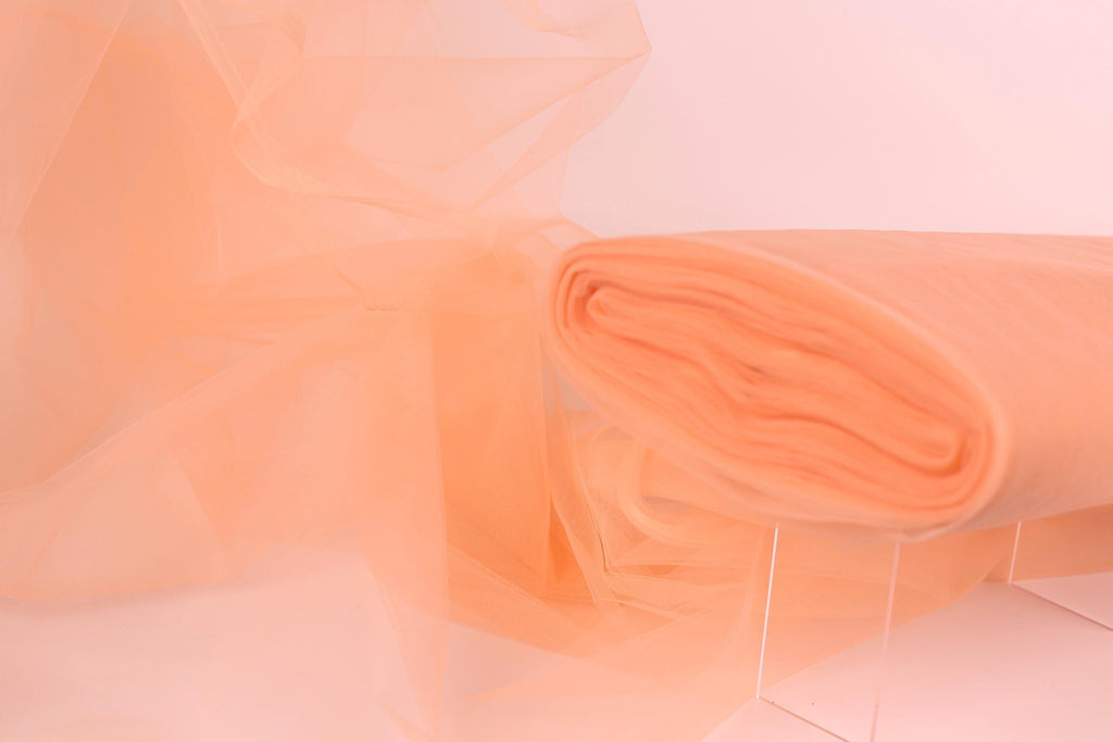 a close-up view of a piece of orange fabric, possibly tulle, with a soft, flowing texture.