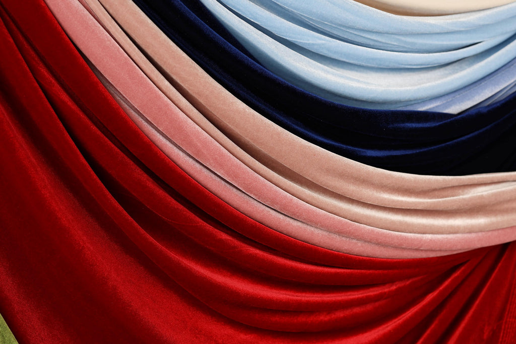 a close-up view of a collection of colorful fabric swatches, including red, pink, blue, and black.