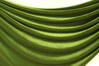 a close-up view of a shiny, green fabric with a smooth, flowing texture. The fabric appears to be made of a shiny, satin-like material, giving it a luxurious and elegant appearance.